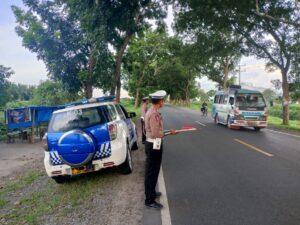 Implementasi Program Kapolri. Polantas Batu Bara Kibas Bendera di Sore Hari.